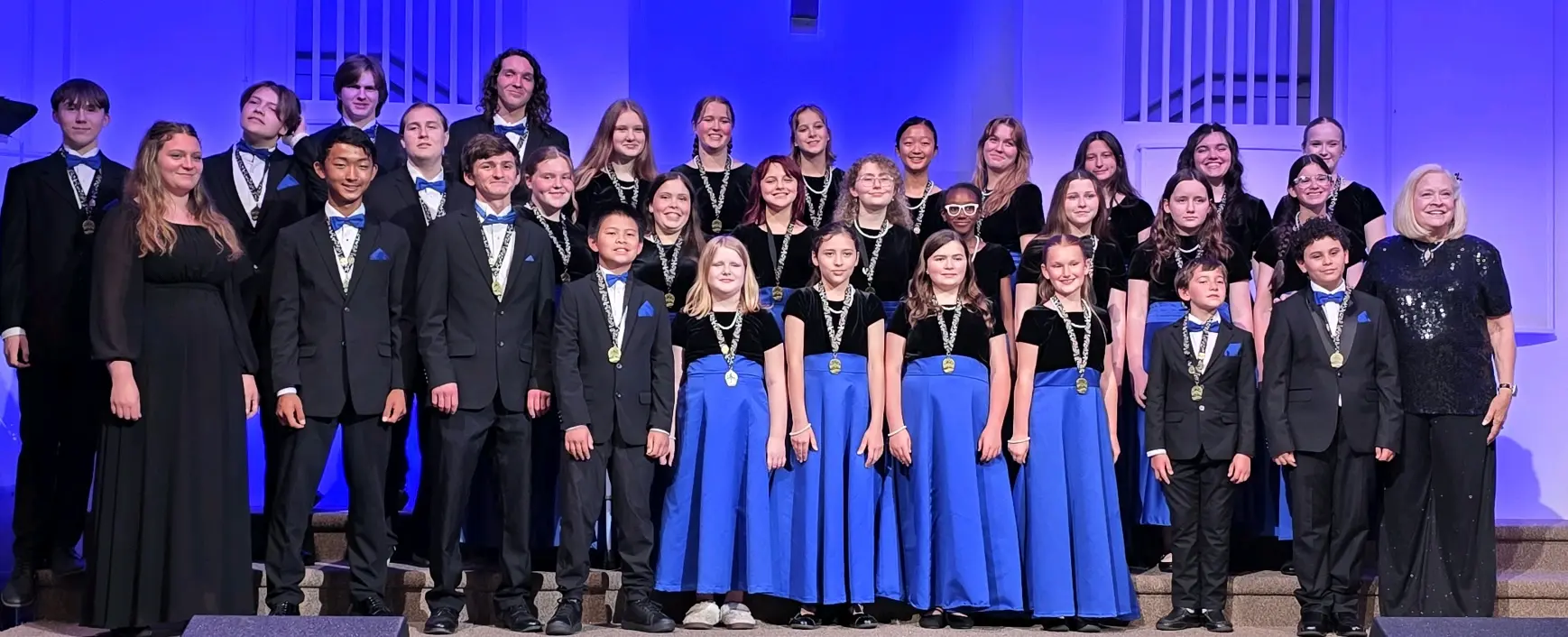 The full Salisbury Children's Choir posed on stage in concert dress